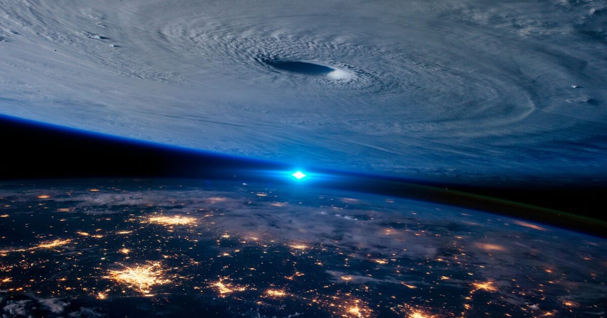 台風の目と夜の都市が見える地球の衛星画像