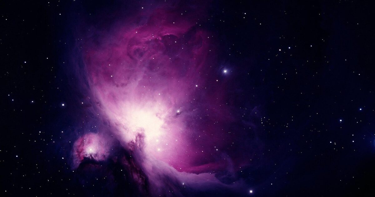 ピンク色に輝く幻想的な星雲と宇宙空間