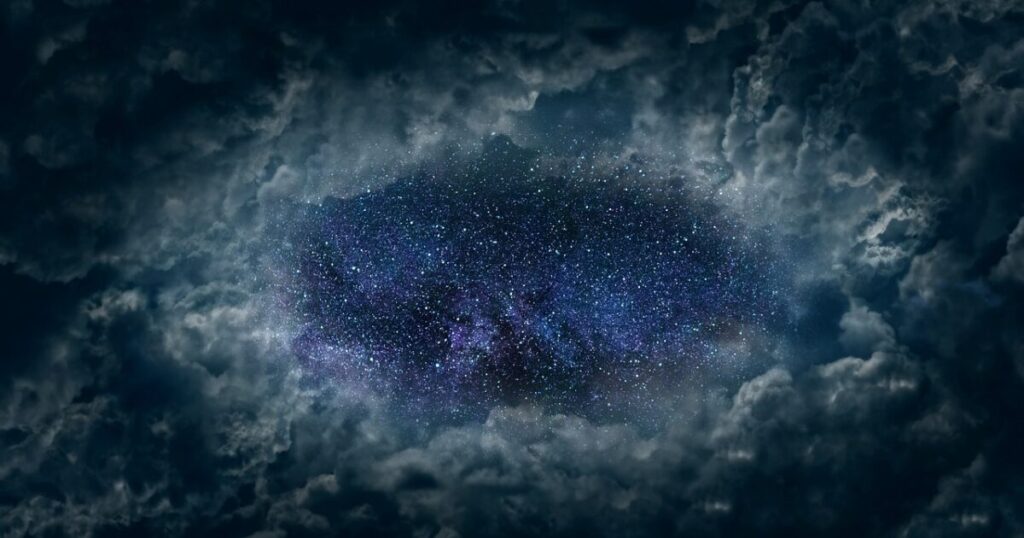 雲の隙間から見える星空と銀河の風景